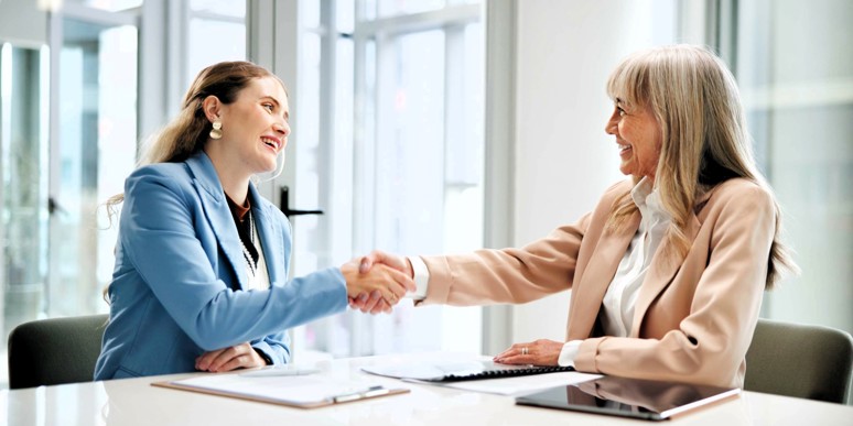 Women shaking hands after signing a contract