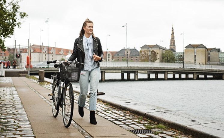 Kvinna som leder cykel