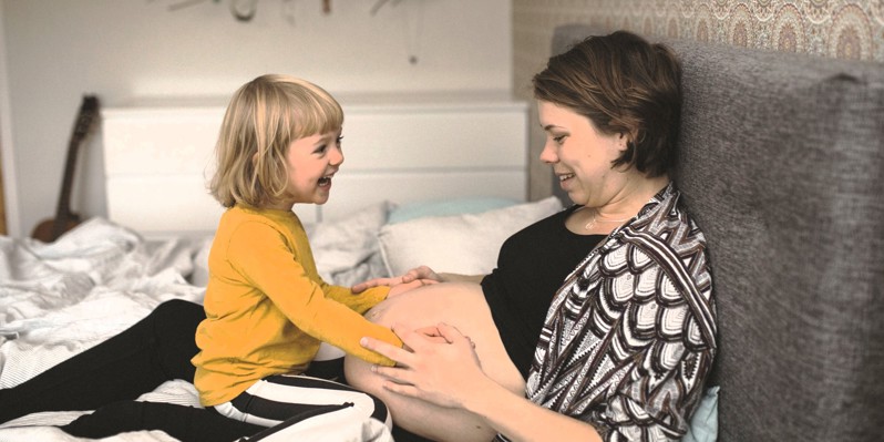 Gravid kvinna tillsammans med sitt barn