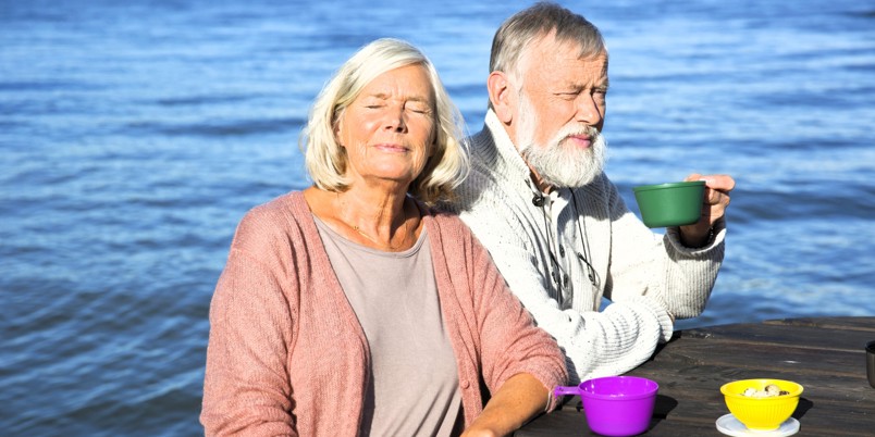Äldre par fikar vid vattnet
